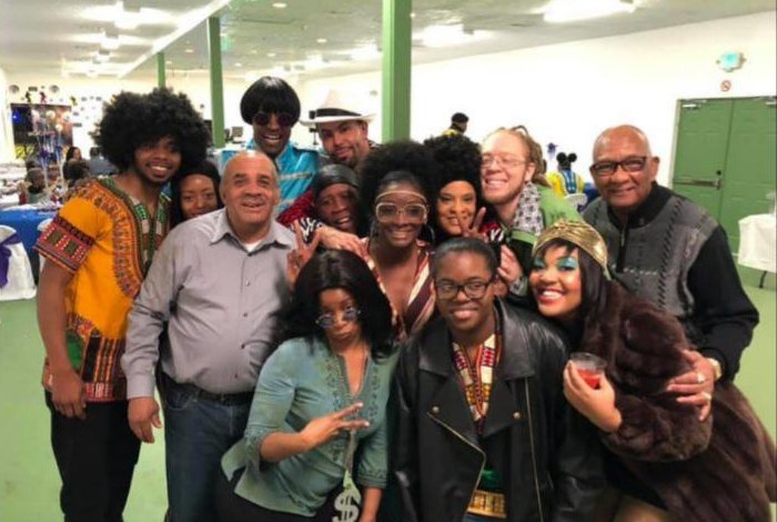 Family members in costume, smiling together at a party